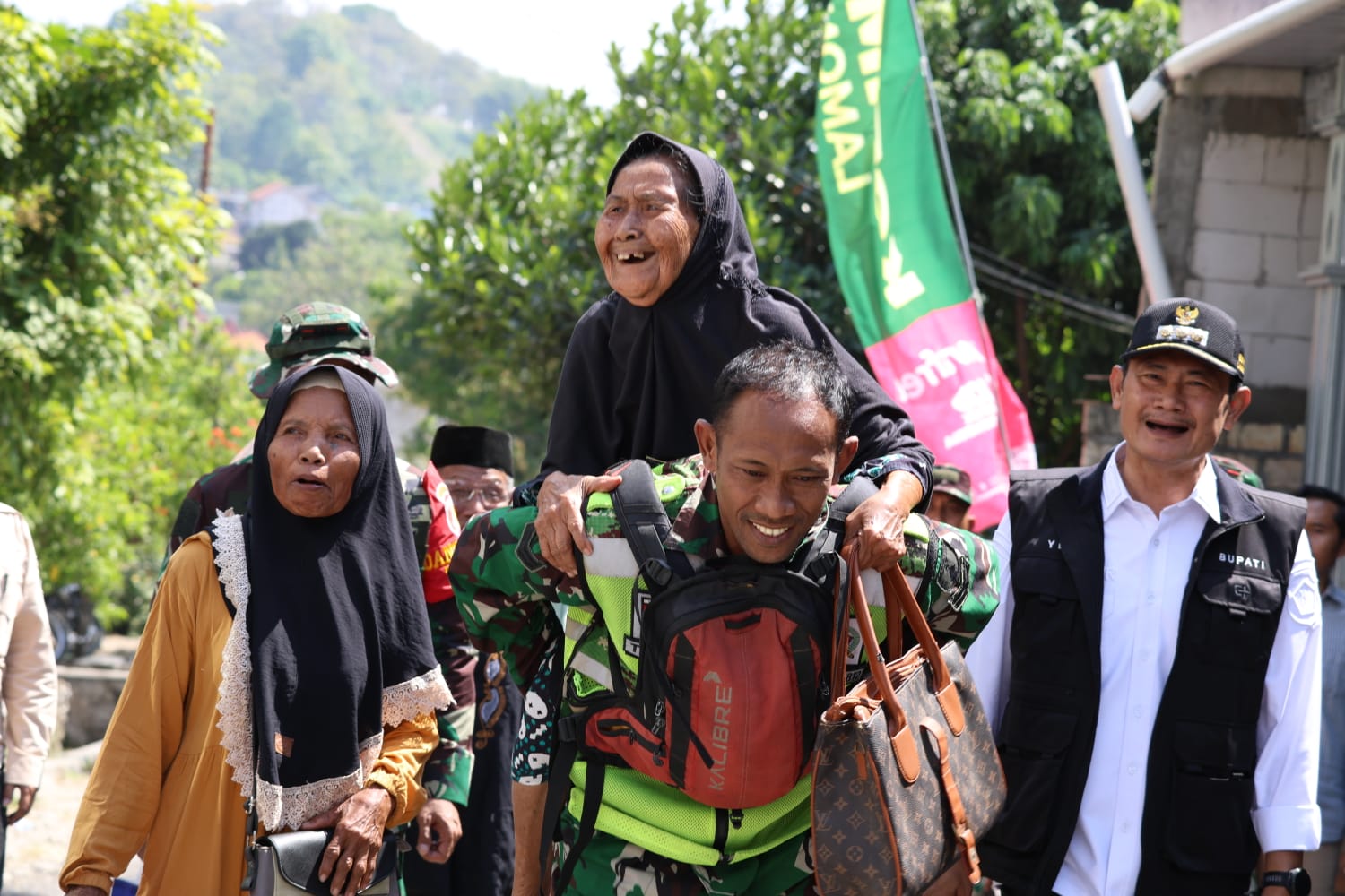 Kegiatan Sosial TMMD 129: TNI Menggendong Lansia Menuju Penyaluran Bantuan Sembako di Lamongan