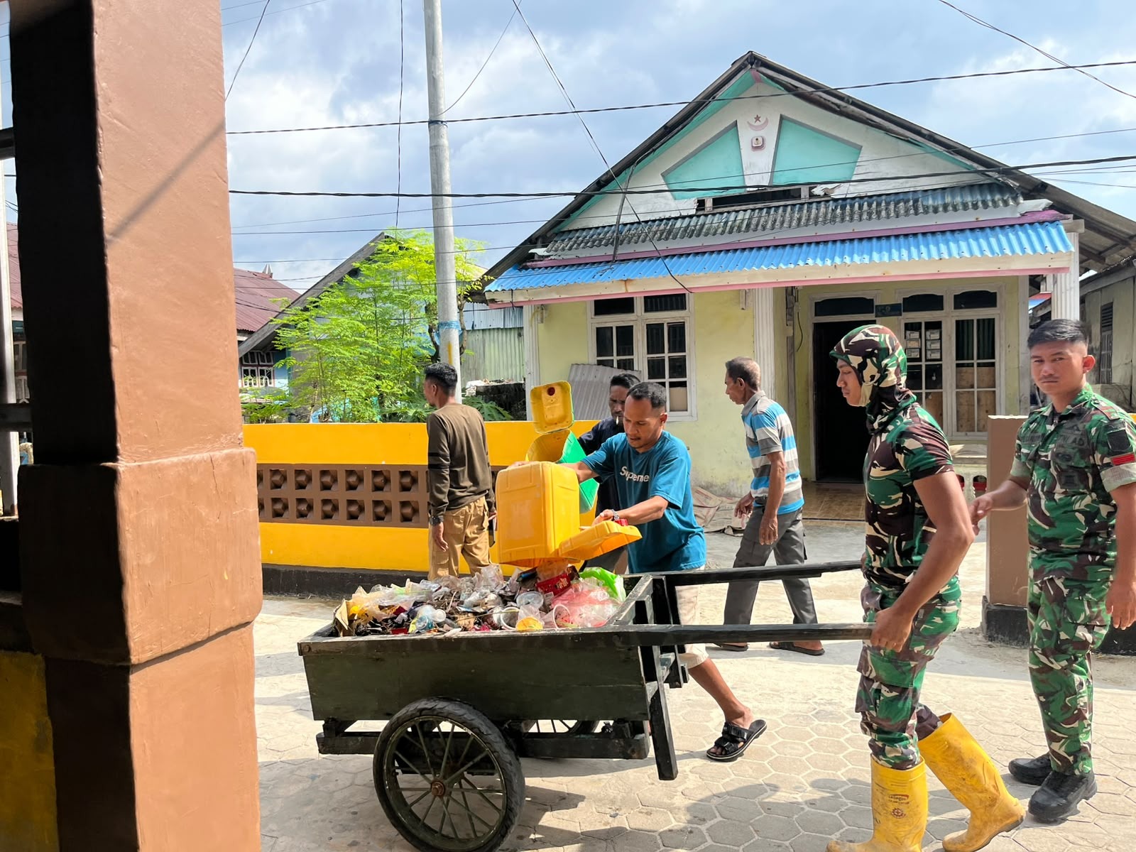 Kerja Sama Satgas TMMD dan Masyarakat dalam Membersihkan Sampah di Desa Umbele